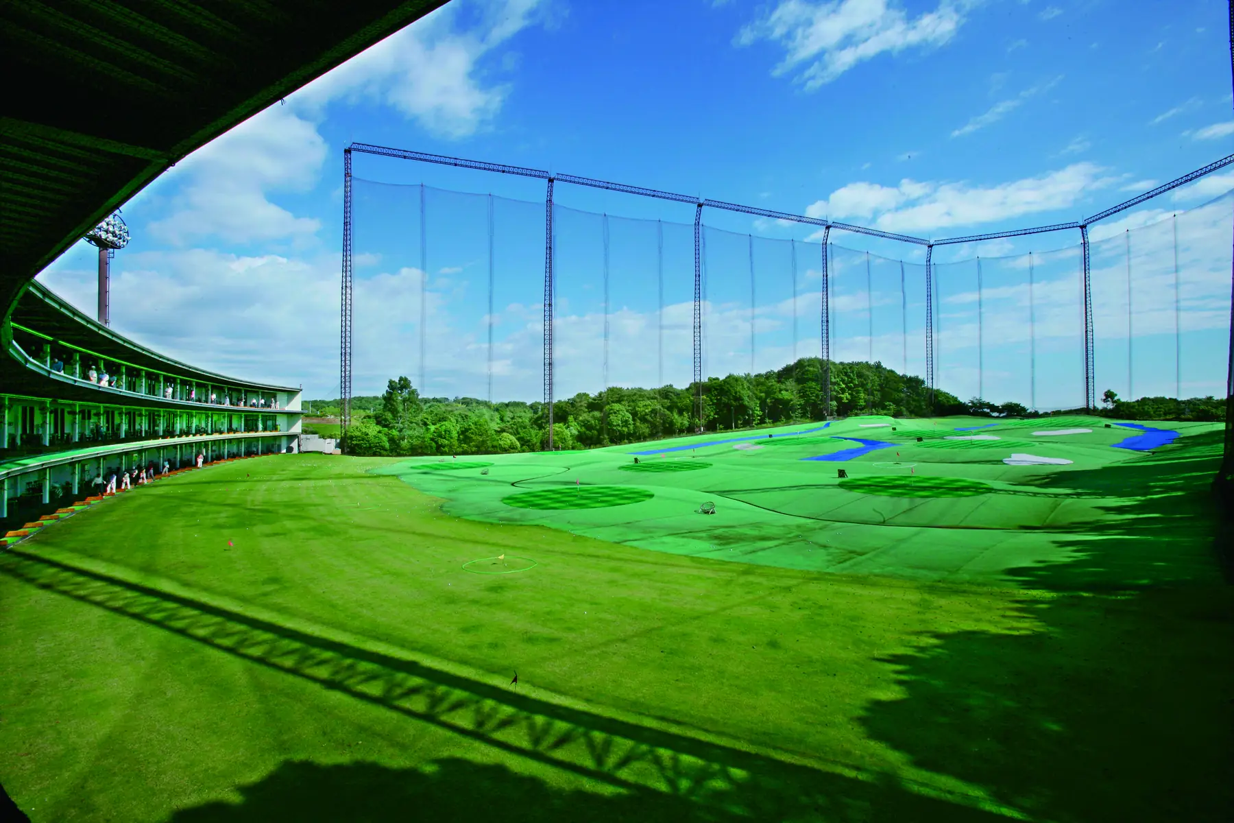 打席から見たHANZ GOLF CLUBのフェアウェイ。青い池とグリーンが外野に広がる。
